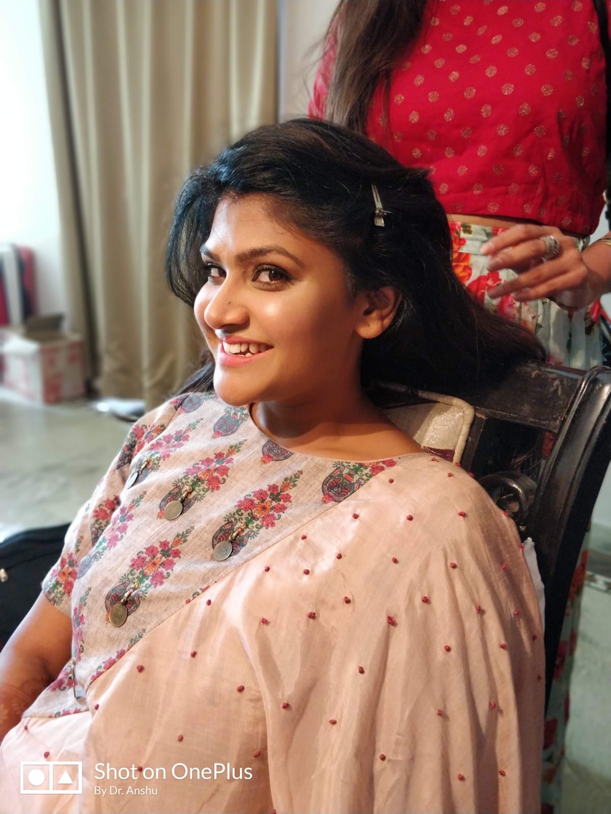 Meenal smiling gently while getting her hair styled